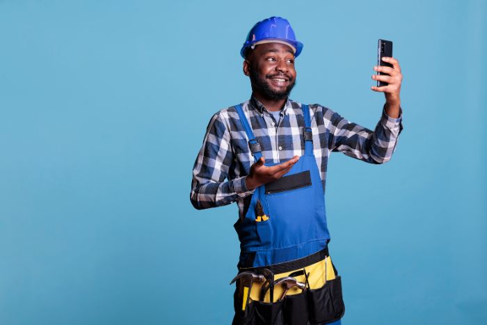 A construction worker smiling during a mobile video call.