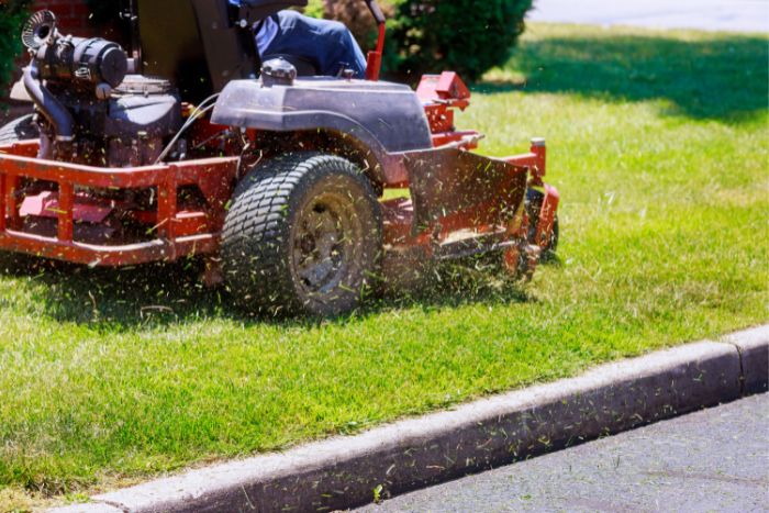 A man mowing a lawn with a riding mower.